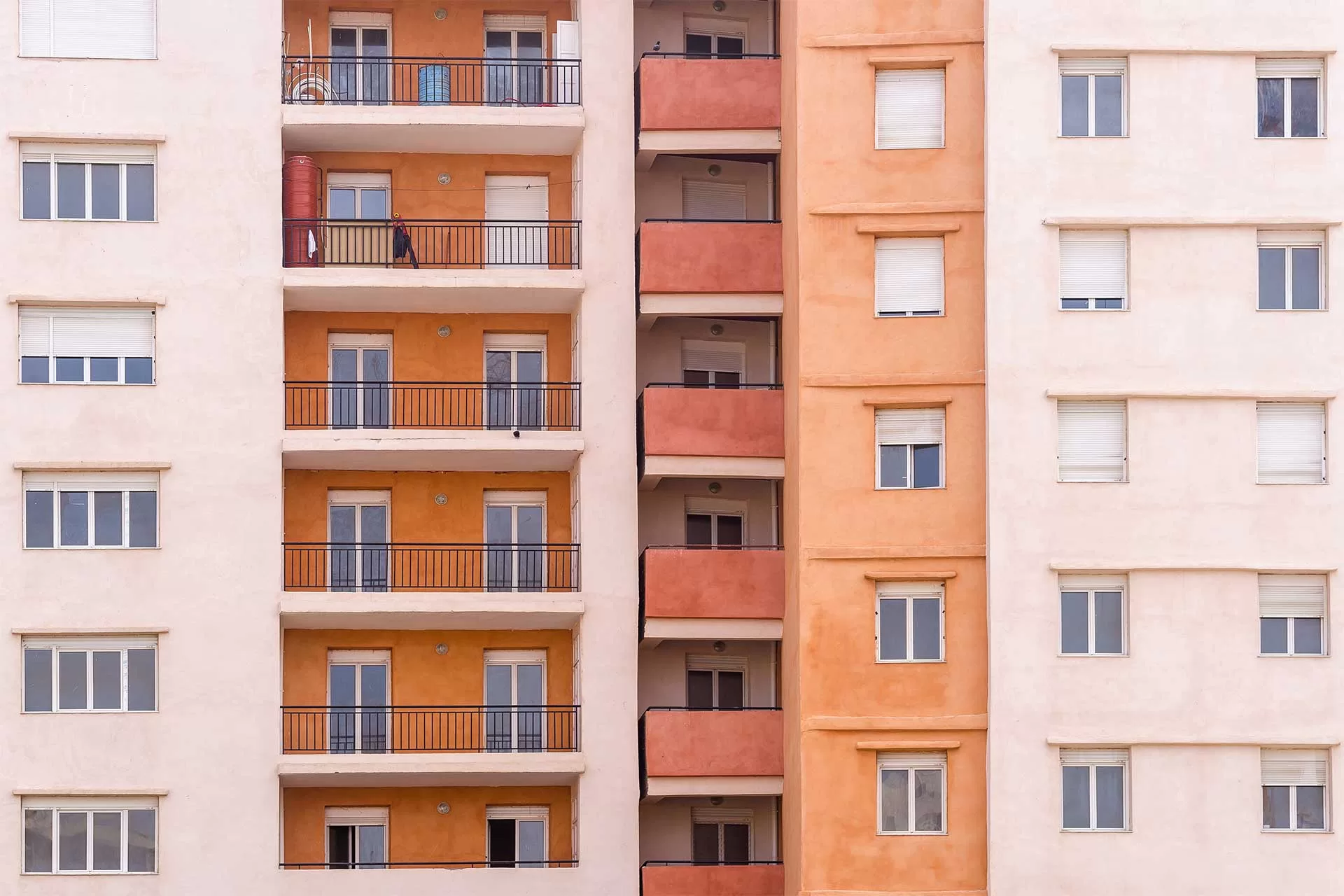 facade d'une construction blanche et orange amenagé avec des fenetre et porte fenetre pvc avec coffre volet roulant et double vitrage isolant