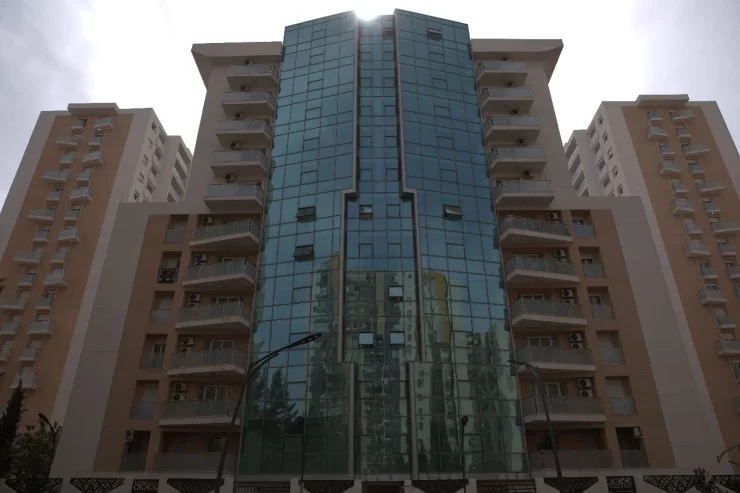 facade d'un immeuble cloturé a bejaia avec des bais vitrés et pose de fenetres pvc oxxo et porte fenetre pvc qui s'ouvent sur des balcons