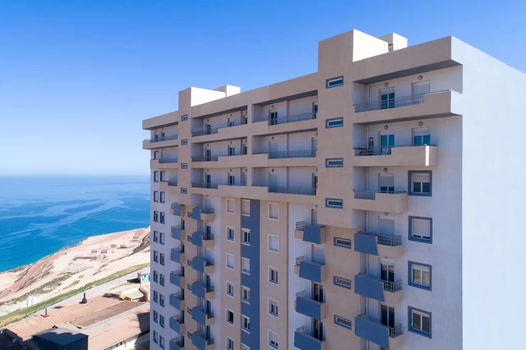 une facade realisée avec des fenetres pvc oxxo dans une promotion immobilere peinte en blanc et beige a coté de la mer a oran